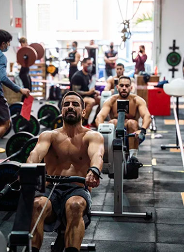 Imagen de personas haciendo ejercicios de fuerza en el gimnasio tomando una clase de Crossfit